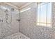 Shower showcasing patterned stone walls, a frosted window, and a multi-setting shower head at 2694 Marvel Astoria St, Henderson, NV 89044
