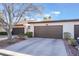 Front view of a tan house with a brown garage door and landscaping at 2847 San Martin Ct, Las Vegas, NV 89121