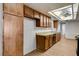 Galley kitchen featuring wood cabinets, updated lighting, and modern appliances at 4440 E Boston Ave, Las Vegas, NV 89104