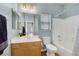 Bathroom with light blue walls, wood vanity, and bathtub at 5962 Bassio Ave, Las Vegas, NV 89141