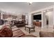 Spacious living room with leather sofas, large TV, and a view into the kitchen at 9641 Cripple Gulch Ct, Las Vegas, NV 89178