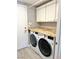 Laundry room with washer, dryer, and ample storage cabinets at 9701 Ann Arbor Ln, Las Vegas, NV 89134