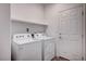 Bright laundry room with washer, dryer, and built-in shelving at 10306 Coastline Creek Ct, Las Vegas, NV 89141