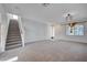 Open living room with staircase, neutral carpeting, and natural light at 10306 Coastline Creek Ct, Las Vegas, NV 89141