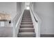 Modern staircase with gray carpeting and black railing at 10306 Coastline Creek Ct, Las Vegas, NV 89141