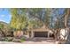 Two-story house with brown garage door and large tree at 11017 Ladyburn Ct, Las Vegas, NV 89141