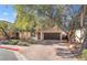 Two-story house with brown garage door and brick driveway, surrounded by trees at 11017 Ladyburn Ct, Las Vegas, NV 89141