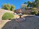 Landscaped backyard with a tiered fountain and seating area at 1260 Corista Dr, Henderson, NV 89052