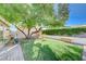 Landscaped backyard with grassy area, mature tree, and stone accents at 1510 Marita Dr, Boulder City, NV 89005