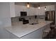 Modern kitchen features white cabinets, quartz countertops, and stainless steel appliances at 1908 Quail Point Ct, Las Vegas, NV 89117