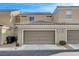 Tan two-story townhome with two-car garage at 2077 Via Firenze, Henderson, NV 89044