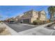 Row of tan townhomes with garages at 2077 Via Firenze, Henderson, NV 89044