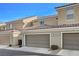 Tan two-story townhome with two-car garage at 2077 Via Firenze, Henderson, NV 89044