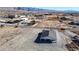 An aerial view showcases a house with a large lot, surrounded by desert landscape at 2560 Tahachapi Ave, Pahrump, NV 89048