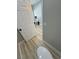 Modern bathroom featuring wood-look flooring and a sleek design with a toilet and neutral color palette at 2560 Tahachapi Ave, Pahrump, NV 89048