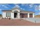 Single-story home with three-car garage, and landscaped front yard at 2560 Tahachapi Ave, Pahrump, NV 89048