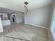 Stylish living room with wood-look flooring, modern lighting, and an open view into the kitchen at 2560 Tahachapi Ave, Pahrump, NV 89048