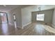 Bright, open-concept living room featuring wood-look floors, neutral walls, and modern light fixture at 2560 Tahachapi Ave, Pahrump, NV 89048