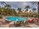 Resort style pool with lounge chairs, palm trees and a beautiful clubhouse in the background at 260 E Flamingo Rd # 433, Las Vegas, NV 89169