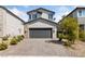 Two-story house with gray exterior, dark garage door, and landscaped front yard at 2720 High Echelon Rd, North Las Vegas, NV 89086