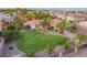 Aerial view of a house with a beautifully landscaped yard, featuring palm trees and a curved lawn at 274 Doobie Ave, Las Vegas, NV 89183