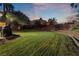 Large backyard with a grassy area at dusk at 274 Doobie Ave, Las Vegas, NV 89183