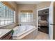 Bathroom with corner bathtub and view into bedroom at 274 Doobie Ave, Las Vegas, NV 89183