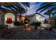 Home entrance with red doors, fountain, and palm trees at dusk at 274 Doobie Ave, Las Vegas, NV 89183