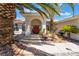 House entryway with red door and a landscaped area with palm trees at 274 Doobie Ave, Las Vegas, NV 89183