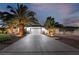 House exterior at dusk featuring palm trees, a driveway, and landscape lighting at 274 Doobie Ave, Las Vegas, NV 89183