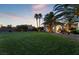 House exterior at dusk, featuring a manicured lawn, palm trees, and a fountain at 274 Doobie Ave, Las Vegas, NV 89183