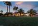 House exterior at dusk with a large lawn and palm trees at 274 Doobie Ave, Las Vegas, NV 89183