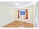 Simple bedroom with wood flooring and a window with orange curtains at 3169 Nottingham Dr, Las Vegas, NV 89121