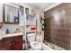 Clean bathroom with brown tile shower surround and wood vanity at 35 Jade Cir, Las Vegas, NV 89106