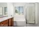 Clean bathroom with shower, tub, and wood cabinets at 3728 Shallow Dove Ct, North Las Vegas, NV 89032