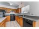 Kitchen with oak cabinets, black appliances, and a granite countertop at 4850 Aveneda Grande, Las Vegas, NV 89121