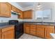 Kitchen with oak cabinets, black appliances, and granite countertops at 4850 Aveneda Grande, Las Vegas, NV 89121