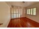 Bright bedroom with hardwood floors, built-in shelves, and sliding door to balcony at 4974 Crooked Stick Way, Las Vegas, NV 89113