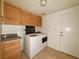 Laundry room with washer, dryer, and wood cabinets at 4974 Crooked Stick Way, Las Vegas, NV 89113