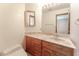 Bathroom featuring wooden cabinets, stone countertop, updated mirror, and tile flooring at 56 Sawgrass Ct, Las Vegas, NV 89113