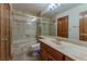 Bathroom with marbled shower, marble countertops and wood cabinets, exuding elegance and functionality at 56 Sawgrass Ct, Las Vegas, NV 89113