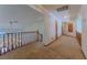 Upstairs hallway featuring chandelier, wood railing, and carpet floors at 56 Sawgrass Ct, Las Vegas, NV 89113