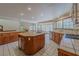 An open kitchen with wood cabinets, island, tile flooring, and ample natural light at 56 Sawgrass Ct, Las Vegas, NV 89113