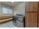 Bright laundry room with stainless steel washer and dryer, wood cabinets, and tiled floor at 56 Sawgrass Ct, Las Vegas, NV 89113