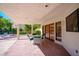 Covered patio with brick flooring, ample seating, and access to the landscaped backyard at 56 Sawgrass Ct, Las Vegas, NV 89113