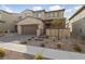 Two-story house with a brown garage door and landscaped front yard at 595 Beverly Pine Pl, Henderson, NV 89011