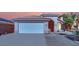 Single-story house with a two-car garage and landscaped yard at 6458 Bluehurst Ave, Las Vegas, NV 89156