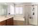 Bright bathroom featuring a separate shower, soaking tub, and a large window for natural light at 658 Forest Peak St, Henderson, NV 89011
