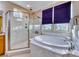 Spa-like bathroom with marble finishes, soaking tub, and shower at 70 Portezza Dr, Henderson, NV 89011