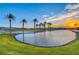 Scenic pond with palm trees at sunset in a resort community at 70 Portezza Dr, Henderson, NV 89011